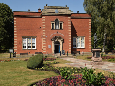 Red brick building of Nuneaton museum and art gallery in Riversley Park on a warm summers day.