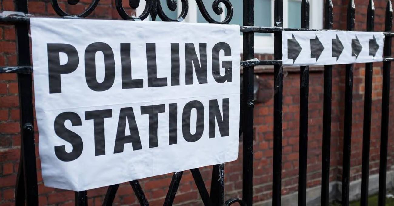 polling station sign attached to black iron railings